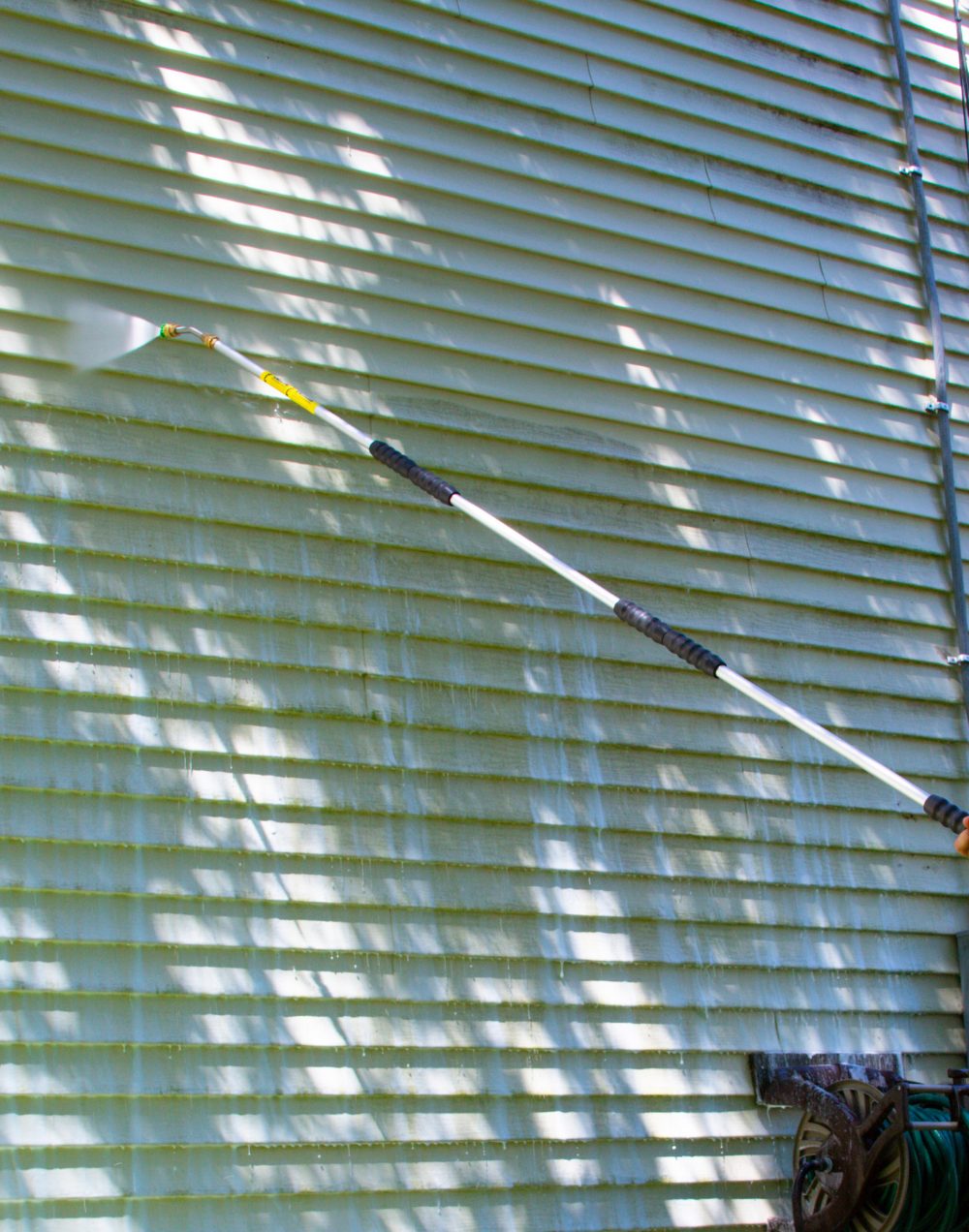 Washing house siding with an extension wand